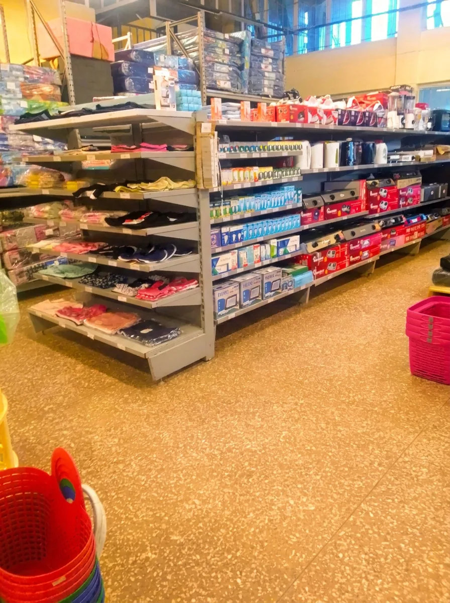 Household essentials aisle with clothing, kettles and homeware on shelves